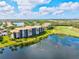 Beautiful aerial view of lakeside condo buildings with tile roofs and lush landscaping near a golf course at 7705 Grand Estuary Trl # 202, Bradenton, FL 34212