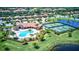 Aerial view of a community clubhouse, swimming pool, tennis courts, and lush landscaping in a serene neighborhood at 7705 Grand Estuary Trl # 202, Bradenton, FL 34212
