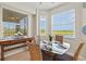 Charming dining area featuring large windows providing scenic views and a stylish glass-top table with seating for four at 7705 Grand Estuary Trl # 202, Bradenton, FL 34212