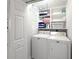 Laundry room with washer and dryer, storage shelves, and white cabinets at 7705 Grand Estuary Trl # 202, Bradenton, FL 34212