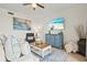 Well-lit living room featuring comfortable seating and a view of the beautiful beach on television at 7705 Grand Estuary Trl # 202, Bradenton, FL 34212