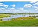 Scenic view of a tranquil pond surrounded by lush greenery and a vibrant blue sky with fluffy white clouds at 7705 Grand Estuary Trl # 202, Bradenton, FL 34212