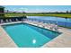 Inviting community pool surrounded by lounge chairs and lush landscaping with views of the lake and golf course at 7705 Grand Estuary Trl # 202, Bradenton, FL 34212
