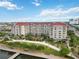 An aerial view of the condo building with a red roof and beautiful landscape at 808 3Rd W Ave # 203, Bradenton, FL 34205