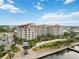 Condo building features pristine landscaping with palm trees by a harbor at 808 3Rd W Ave # 203, Bradenton, FL 34205