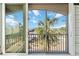 Screened balcony with tile flooring, ceiling fan, and views of lush landscaping and open water at 808 3Rd W Ave # 203, Bradenton, FL 34205