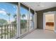 Screened balcony with tile flooring, ceiling fan, and views of lush tropical landscaping and open water at 808 3Rd W Ave # 203, Bradenton, FL 34205