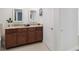 Bathroom with a dual sink vanity, granite countertop, and modern fixtures at 808 3Rd W Ave # 203, Bradenton, FL 34205