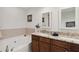 Bright bathroom features double granite-topped vanities, tile accents, and a large soaking tub at 808 3Rd W Ave # 203, Bradenton, FL 34205