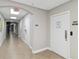 Long hallway with tiled floor, white walls, and multiple doorways leading to different rooms at 808 3Rd W Ave # 203, Bradenton, FL 34205