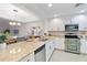 Modern kitchen featuring granite countertops, stainless steel appliances, and white cabinetry at 808 3Rd W Ave # 203, Bradenton, FL 34205