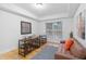 Neutral living room features a seating area, decorative art, and natural light from the window at 808 3Rd W Ave # 203, Bradenton, FL 34205