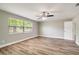 Bright bedroom features wood-look flooring, ceiling fan, a large window and neutral wall color at 8308 Pelican Rd, Englewood, FL 34224