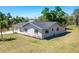 A charming single story home featuring a gray roof and a well-maintained lawn with lush greenery at 8308 Pelican Rd, Englewood, FL 34224