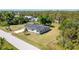 A charming single story home featuring a gray roof and a well-maintained lawn with lush greenery at 8308 Pelican Rd, Englewood, FL 34224