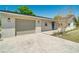 A charming home with a well-manicured lawn, a gray garage door, and a dark blue front door at 8308 Pelican Rd, Englewood, FL 34224