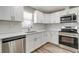 Bright kitchen featuring white cabinets, stainless steel appliances, and quartz countertops at 8308 Pelican Rd, Englewood, FL 34224