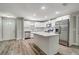 Modern kitchen with stainless steel appliances, white cabinets, and a kitchen island with a white countertop at 8308 Pelican Rd, Englewood, FL 34224