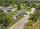 Aerial view of a single-story home with a well-maintained lawn surrounded by lush trees and multiple houses at 8414 Sweden Blvd, Punta Gorda, FL 33982