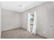 An empty bedroom with neutral-colored walls and carpet and a window with white curtains at 8414 Sweden Blvd, Punta Gorda, FL 33982