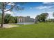 Exterior shot of home framed by mature trees, set on a lush green lawn at 8414 Sweden Blvd, Punta Gorda, FL 33982