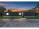 Charming single-story home with a well-maintained lawn during a sunset at 8414 Sweden Blvd, Punta Gorda, FL 33982