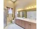 Bathroom featuring a double sink vanity, tiled floors, and walk-in shower with decorative curtains at 95 Vic Edwards Rd, Sarasota, FL 34240