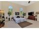 Well-lit bedroom with a bed, dresser, plants, and large windows at 95 Vic Edwards Rd, Sarasota, FL 34240