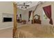 Spacious main bedroom featuring a seating area, TV, and canopy bed with elegant red drapes at 95 Vic Edwards Rd, Sarasota, FL 34240