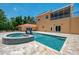 Beautiful outdoor pool and spa area with travertine tile and an outdoor structure at 95 Vic Edwards Rd, Sarasota, FL 34240