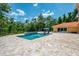 Beautiful outdoor pool and spa area with travertine tile, lush landscaping, and plenty of space for entertaining at 95 Vic Edwards Rd, Sarasota, FL 34240