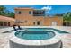 Beautiful outdoor pool and spa area with travertine tile, lush landscaping, and an outdoor structure at 95 Vic Edwards Rd, Sarasota, FL 34240