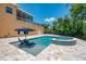 Outdoor pool and spa area with travertine tile, lush landscaping, and sitting area at 95 Vic Edwards Rd, Sarasota, FL 34240