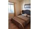 Cozy bedroom with a wicker headboard bed, side table with lamp, and natural light from a window at 1030 Tidewater Shores Loop # 404, Bradenton, FL 34208
