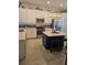 Modern kitchen featuring white cabinets, stainless steel appliances, decorative backsplash, and a stylish blue kitchen island at 1030 Tidewater Shores Loop # 404, Bradenton, FL 34208