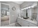 Bathroom boasting double sinks, granite countertop, and an open door to bedroom at 12715 Wheatgrass Ct, Parrish, FL 34219