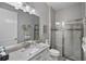 Modern bathroom with sleek vanity, large mirror, and glass-enclosed shower, featuring neutral tones at 12715 Wheatgrass Ct, Parrish, FL 34219