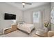 This bedroom features neutral decor, a window with shutters, ceiling fan, and a wall-mounted television at 12715 Wheatgrass Ct, Parrish, FL 34219