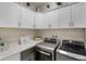 Functional laundry room with modern washer and dryer, ample counter space, and upper cabinets at 12715 Wheatgrass Ct, Parrish, FL 34219