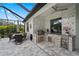 Covered outdoor kitchen and dining area within a screened enclosure at 12715 Wheatgrass Ct, Parrish, FL 34219