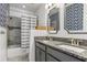 This is a bathroom with gray cabinets, granite countertop and blue and white patterned wallpaper at 13721 Saw Palm Creek Trl, Lakewood Ranch, FL 34211
