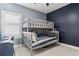 Cozy bedroom with a gray bunk bed, navy accent wall, and a bright, sunlit window at 13721 Saw Palm Creek Trl, Lakewood Ranch, FL 34211
