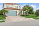 Charming two-story home featuring a brick driveway, a teal garage door, and a well-manicured lawn at 13721 Saw Palm Creek Trl, Lakewood Ranch, FL 34211