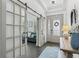 Inviting foyer with wood floors, glass French doors, modern lighting, and an elegantly decorated front door at 13721 Saw Palm Creek Trl, Lakewood Ranch, FL 34211