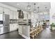 Modern kitchen featuring white cabinets, a large center island, stainless steel appliances, and stylish pendant lighting at 13721 Saw Palm Creek Trl, Lakewood Ranch, FL 34211