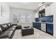 Stylish living room with wet bar, navy accents, modern furniture, and ample natural light at 13721 Saw Palm Creek Trl, Lakewood Ranch, FL 34211
