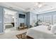 Airy main bedroom with ensuite bath, television, seating and bright shuttered windows at 13721 Saw Palm Creek Trl, Lakewood Ranch, FL 34211