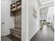 Convenient mudroom with built-in bench, storage shelves, and hooks for organization, next to the hall at 13721 Saw Palm Creek Trl, Lakewood Ranch, FL 34211
