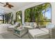 Covered patio with wicker furniture, ceiling fan, lighting, and view of the tropical backyard at 13721 Saw Palm Creek Trl, Lakewood Ranch, FL 34211