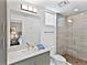 Bathroom featuring quartz counters, large mirror, walk-in shower, and bedroom view at 1709 N Tamiami Trl # 318, Sarasota, FL 34234